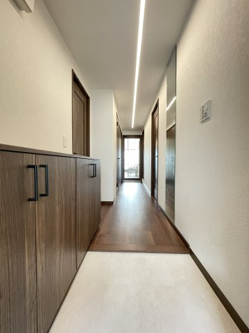 グランデュール鴨川Ⅱ番館の玄関|落ち着いた上品なカラーで統一された玄関です。シューズボックス向かいに壁付けミラーを設置。お出かけ前の身だしなみチェックに便利です。