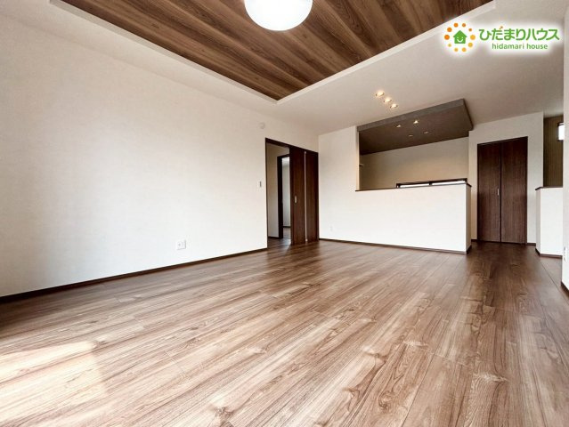 羽生市砂山第1期　新築一戸建て　ワイウッドコート11の居間・リビング|折上天井採用の開放感のあるLDK♪木目の床と白い壁が明るさを引き立て、落ち着いた雰囲気の中で家族が自然と集まる空間です。ゆとりある広さが毎日の時間を豊かにし、安心して過ごせる居心地の良さが魅力です！