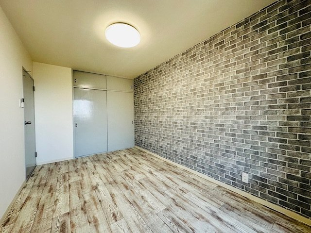 若草マンションの洋室|レンガ調のアクセントクロスが印象的な洋室。