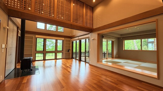 【商談中】【動画付き】中軽井沢 あさまテラス 緑に抱かれるガレージ付の中古平家建ての居間・リビング|ウッドデッキと和室とも一体感を持つLDKには、象徴的な薪ストーブを設置。