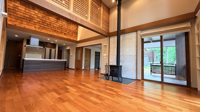 【商談中】【動画付き】中軽井沢 あさまテラス 緑に抱かれるガレージ付の中古平家建ての居間・リビング|木の温もりに包まれた、薪ストーブのある吹き抜けリビング。