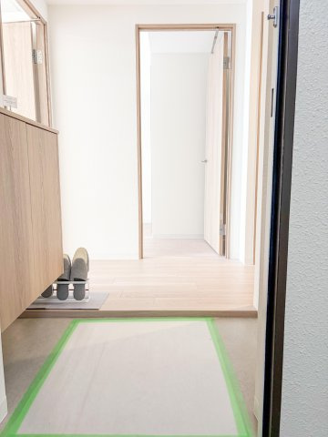 【玄関】すっきり片付くシューズボックス付き。白と木目を基調とした清潔感溢れる玄関空間。