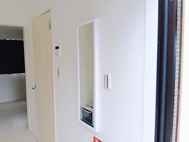 売アパート　静岡市清水区三保の玄関|玄関の壁に全身鏡あり。頭から足元まで全身のコーディネートを確認でき、外出前の最終チェックに便利です。