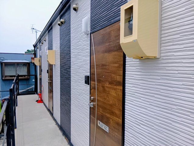 売アパート　静岡市清水区三保のその他共用部分|木目調の玄関ドアがスタイリッシュな2階共用廊下。2階ならではの眺望と風通しで気持ちよく出入りできます。