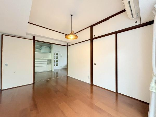 藤和大倉山コープの寝室|寝室は明るく広々とした空間が広がっており落ち着いた雰囲気が感じられます。ふすまのデザインがアクセントとなり収納にも便利です。天井の照明が室内をやさしく照らしています。エアコン付きで快適に過ごせます。