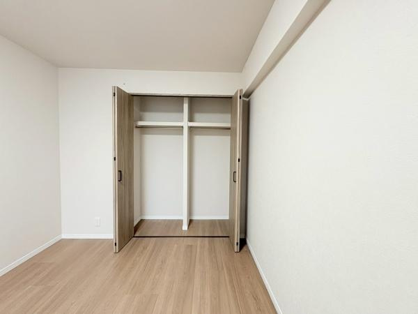 綱島ハイムの収納|ナチュラルな色合いのクローゼットがシンプルな室内によく調和しています。大きな引き戸で出し入れもしやすく整理整頓にも役立ちます。仕切りや棚も備わっているため多様な用途でご利用いただけます。