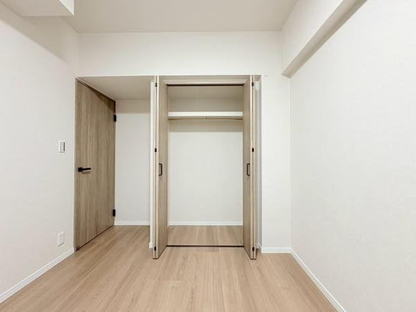 綱島ハイムの収納|ナチュラルな色合いの床と建具がすっきりとした収納スペースです。扉が大きく開くため物の出し入れがしやすくなっています。収納内部にはハンガーパイプと棚が設置されています。