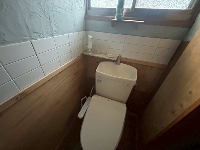 国道アクセス良好。天窓付LDK・テラス完備の多用途な平屋～鹿児島市小山田町～のトイレ|清潔感のある温水洗浄便座。手洗い場と小物棚を備えたトイレ