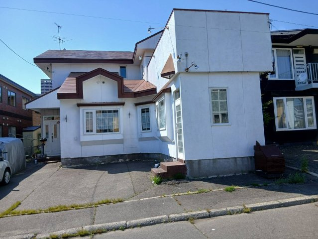 芦野5丁目★広々55坪の店舗付き住宅が980万円！の前面道路含む現地写真|白を基調とした個性的な外観が目を引く店舗併用住宅。