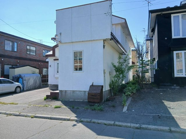 芦野5丁目★広々55坪の店舗付き住宅が980万円！の前面道路含む現地写真|青空に映える白い外観。駐車スペースも完備し店舗に最適です。