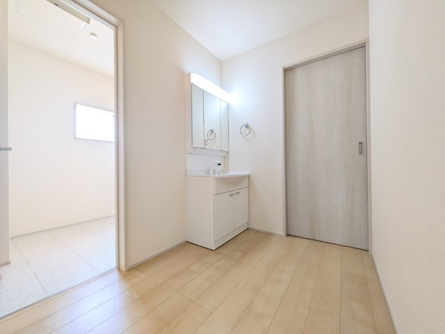 【新築戸建】　いわき市四倉町上仁井田2期　長期優良住宅の脱衣所|1号棟写真　収納スペースが豊富で、鏡の周りには棚もあるため、洗顔用品や歯ブラシ、うがい用のコップ、整髪料、スキンケア用品、化粧品などを置いて整理することができます。