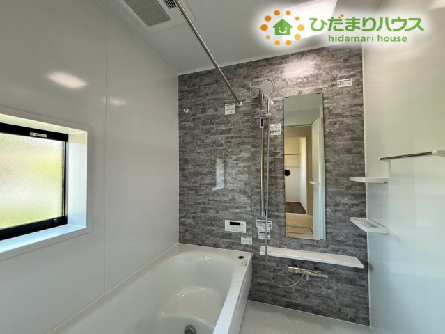 鴻巣市下忍　3期　新築一戸建て　グラファーレ　02の浴室|落ち着いた色合いのアクセントパネルが、リラックスできる空間を演出するお風呂です！大きな窓からは、明るい光が差し込み、毎日の入浴タイムを快適に過ごせます♪浴室乾燥機付きで、雨の日のお洗濯も安心です！