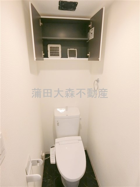 スカイコートパレス蒲田Ⅱのトイレ|窓付き吊戸棚と温水洗浄便座付きのトイレ