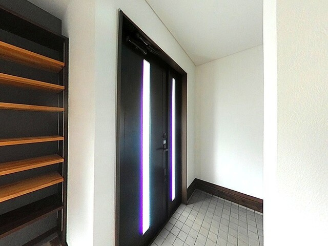 「広々12帖の主寝室」高知市春野町南ヶ丘7丁目　中古一戸建ての玄関|モダンなデザインの玄関ドアが、住まいの顔をスタイリッシュに演出。