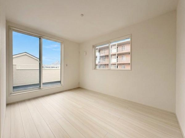 横浜市港北区鳥山町の新築一戸建の居間・リビング|大きな窓からたっぷりと光が差し込むリビングです。明るい色合いのフローリングが空間をより広く見せてくれます。シンプルな内装で多様なインテリアに対応できます。3階バルコニーの景色も楽しめます。