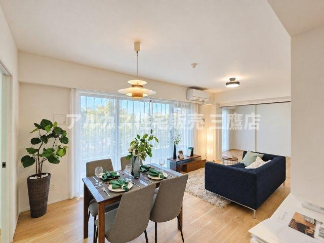 D’クラディアひばりが丘RESIDENCEの居間・リビング|採光豊かな窓辺に面した明るいリビングダイニング。観葉植物やこだわりの照明が映える開放感ある室内デザインです。