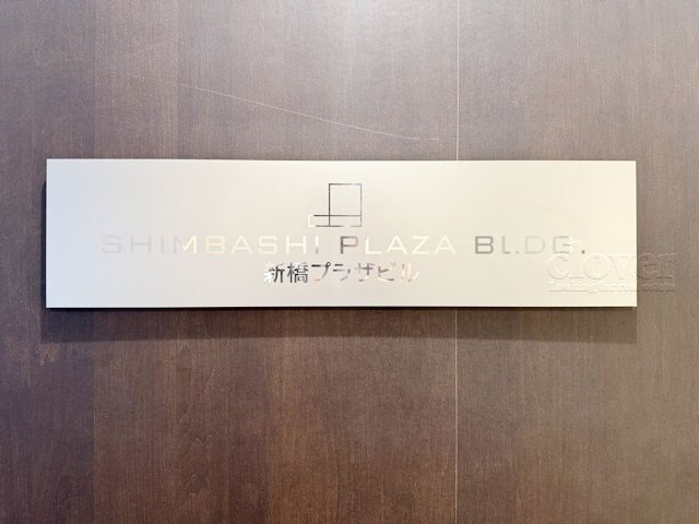 【現況写真】 | 新橋プラザビル | エントランスに掲げられた、マンション名を示す館銘板。さほど激しく主張はしませんが、しっかりと掲示されています。～即日のご見学可能～　お問合せはお気軽にどうぞ。
