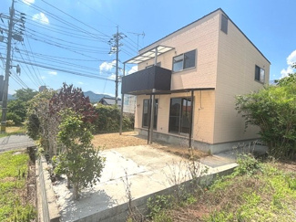 【玄関】 | 東広島市八本松町原【リフォーム済】【3LDK】【中古戸建】【52坪】 | 敷地内には、愛車を雨風や日差しから守るカーポートが設置されています。前面道路からの出入りもしやすく、日当たりや通風にも恵まれた一戸建て物件。青空に映えるツートンカラーの外観デザインです。