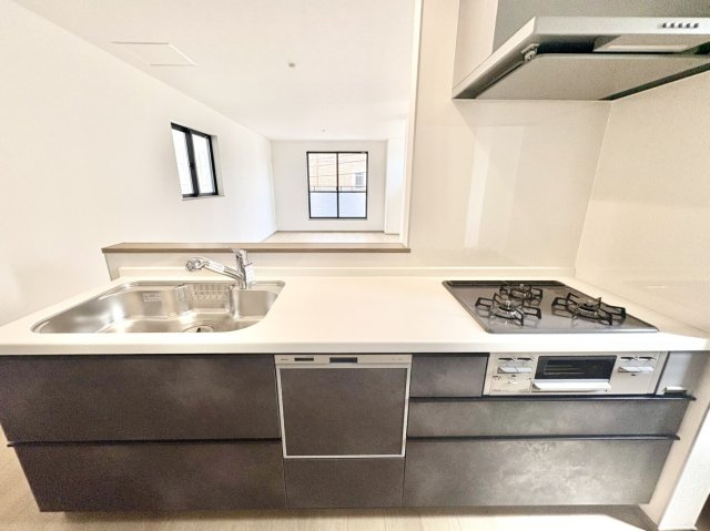 魚崎南町6丁目新築戸建A号棟のキッチン|高級感のあるシックな内装カラーが魅力の対面式キッチン。シンクの前からは19.1帖の大空間リビングまで遮るものなく見渡せます。お料理中もお子様の様子に目が届くため、子育て世帯も安心の設計です