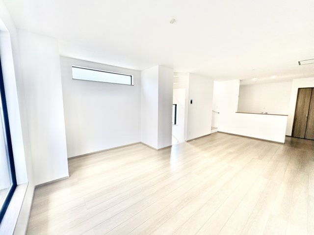 魚崎南町6丁目新築戸建A号棟の居間・リビング|家族全員でのびのび過ごせる、ゆとりの約19.1帖の大空間LDK。明るい内装は開放感をさらに引き立て、大型ソファやダイニングセットも美しく収まります。新築ならではの憧れの広々リビングです。