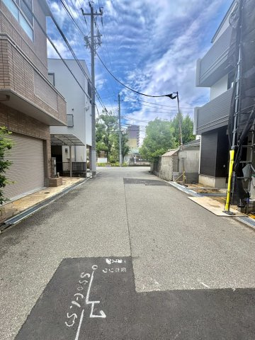 魚崎南町6丁目新築戸建B号棟の前面道路含む現地写真|南側の前面道路は幅員約6.1mとゆとりある広さを確保。大型車でも切り返しがしやすく、毎日の駐車や対向車とのすれ違いもストレスフリーです。運転が苦手な方でも安心して暮らせる快適な住環境です。