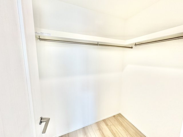魚崎南町6丁目新築戸建B号棟の収納|約8.2帖の洋室内に設けられた、使い勝手の良いフリールームです。L字型に配されたハンガーパイプと上部の枕棚により、春夏秋冬の衣類や、スーツケースや季節物の家電までまとめて1か所に美しく収納できます。