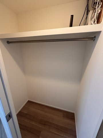 主寝室には、衣類をたっぷり収納できるウォークインクローゼットを完備しました。ハンガーパイプと上段棚を備え、丈の長いコートや季節物の衣類もすっきりと整理可能です。機能的で使いやすい収納スペースです。
