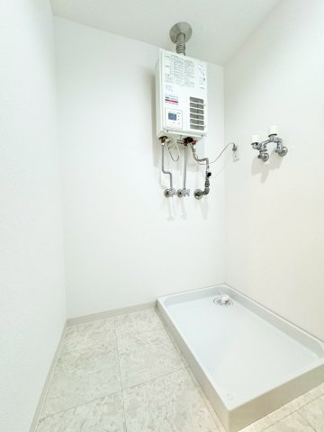 クリオ伏見ホームズの脱衣所|ドラム式洗濯機を設置しても余裕のある洗面所。２０２４年にリフォームして新しくなったボイラーは壁掛けで場所も取らないのが◎