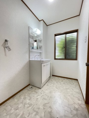【脱衣所】 | 川西市けやき坂1丁目　リフォーム済み中古戸建 | 洗濯機スペースもある、白と基調とした清潔感ある洗面所です