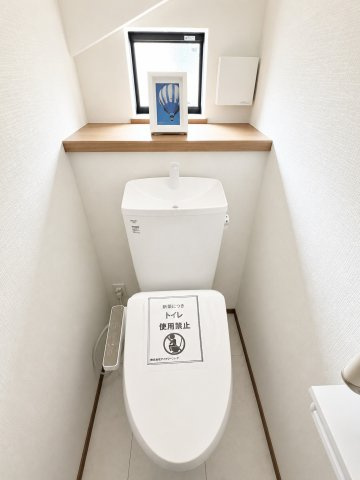 青梅市裏宿町　新築戸建全4棟のトイレ|1階温水シャワートイレ。小物やグリーンを飾れる便利なスペースが、上質で落ち着きのある空間を演出します。