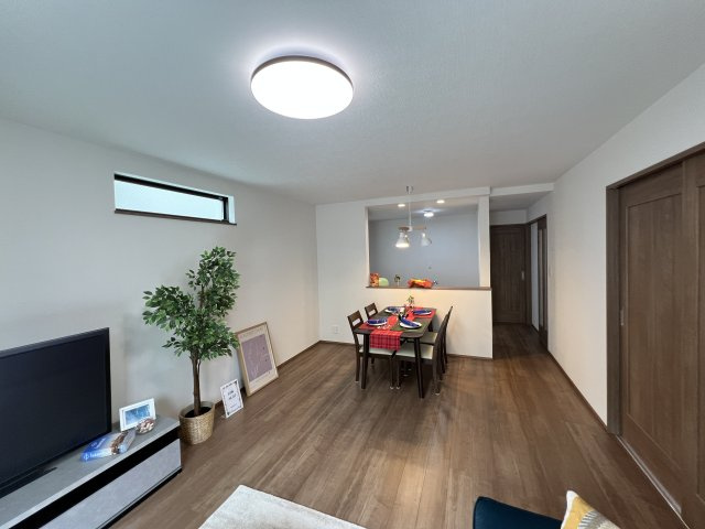 青梅市裏宿町　新築戸建全4棟の居間・リビング|木目調フローリングが温もりを演出する、落ち着きのあるリビング。