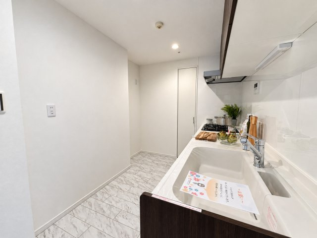 コナ・ヴィレッジ調布国領のキッチン|ホワイトを基調とした清潔感のあるシステムキッチン。広々としたワークトップとシンクで、毎日の料理を快適に行えます。