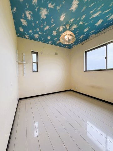 吉川市　二ツ沼　中古戸建の子供部屋|【2階・子供部屋】青空を思わせるアクセント天井が印象的な2階の子供部屋。2面に窓があり、明るく気持ちのよい空間。ベッドや学習机も配置しやすく、お子さまの成長に合わせて長く使いやすい一室。