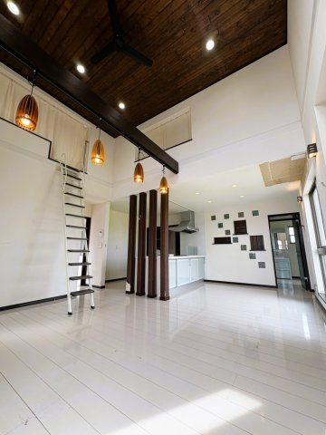 吉川市　二ツ沼　中古戸建の居間・リビング|【2階・21.5帖リビング】21.5帖のゆとりある2階リビング。勾配天井とロフト付きの開放感あふれる空間で、デザイン性の高い照明やシーリングファンが印象的。