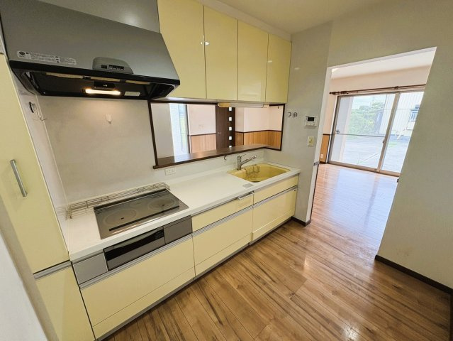 吉川市　二ツ沼　中古戸建のキッチン|【1階・キッチン】リビングを見渡せる対面式キッチン。調理中もご家族との会話を楽しみやすい間取りです。収納スペースもしっかり確保され、IHクッキングヒーターを備えたすっきりとしたキッチン空間。
