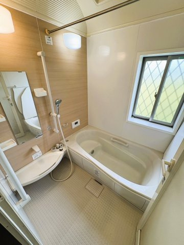 吉川市　二ツ沼　中古戸建の浴室|【1階・浴室】木目調のアクセントパネルが落ち着いた雰囲気を演出するバスルーム。浴室には窓があり、自然換気がしやすいのもうれしいポイント。