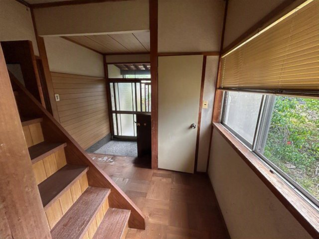 石川県金沢市若松町ツ 中古戸建　～金沢大までアクセス良好！自然に囲まれた環境～の玄関|木目調の壁板と階段横の大きな窓から入る自然光が調和します