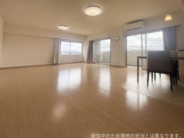 ウエストゲートの居間・リビング|広々としたリビングは明るい雰囲気が特長です。大きな窓からは自然光がたっぷり入ります。バルコニーに出入りしやすいレイアウトです。床の色味が室内をさらに開放的に見せています。家具の配置もしやすい空間です。