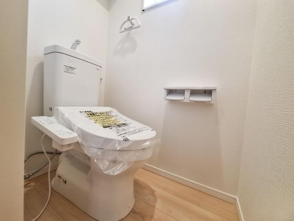 佐野第4-2号棟のトイレ|明るく清潔感のあるトイレ空間です。温水洗浄便座付きで快適にご利用いただけます。シンプルな内装が使いやすい印象です。壁面収納やペーパーホルダーも完備されております。