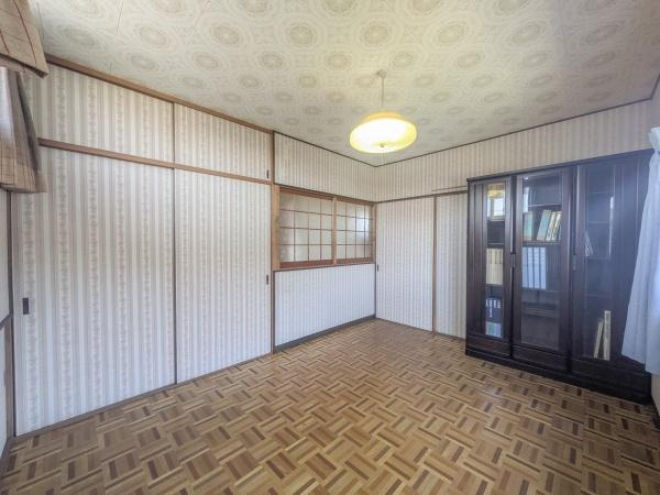 皆春　戸建ての洋室|洋室は明るく開放的な雰囲気が特長です。木目調の床と壁が温かみを感じさせます。収納棚も備え付けられており整理整頓に便利です。窓からは自然光がたっぷり差し込みます。天井の照明もポイントです。