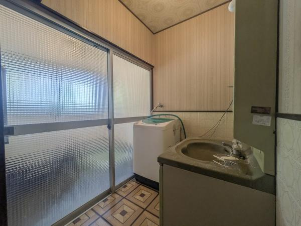 皆春　戸建ての独立洗面台|広々とした洗面所には採光性の高いすりガラス窓があり明るい空間を演出しています。
落ち着いた色合いの壁と床が特徴的です。