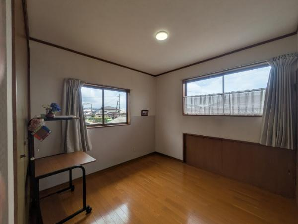 皆春　戸建ての内装|二面採光で室内が明るく感じられます。床は木目が美しく落ち着いた雰囲気の空間です。コンパクトな設計で使いやすい一室です。カーテンや家具の配置も自由に楽しめます。