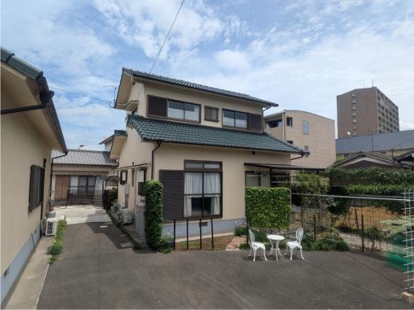 皆春　戸建ての庭|広々とした庭スペースが魅力の一戸建てです。外壁の植物が外観にアクセントを加えています。