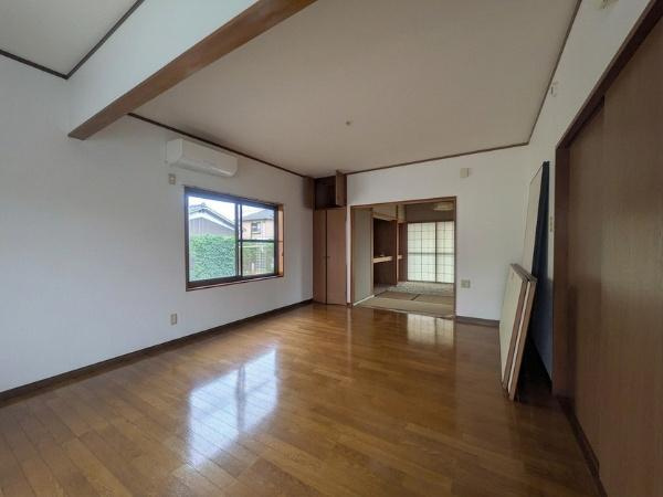 皆春　戸建ての居間・リビング|リビングは広さを感じられる形状で窓から明るい光が差し込みます。隣接する和室とのつながりもあり空間を有効に活用できます。エアコンが設置されているため快適な温度管理が可能です。
