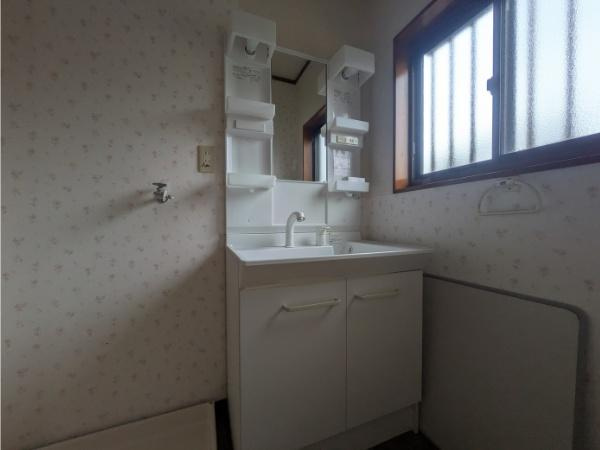 皆春　戸建ての独立洗面台|窓付きで採光性のある洗面所です。収納スペースがしっかりと確保されています。シンプルなデザインの洗面台です。壁紙も落ち着いた雰囲気です。
