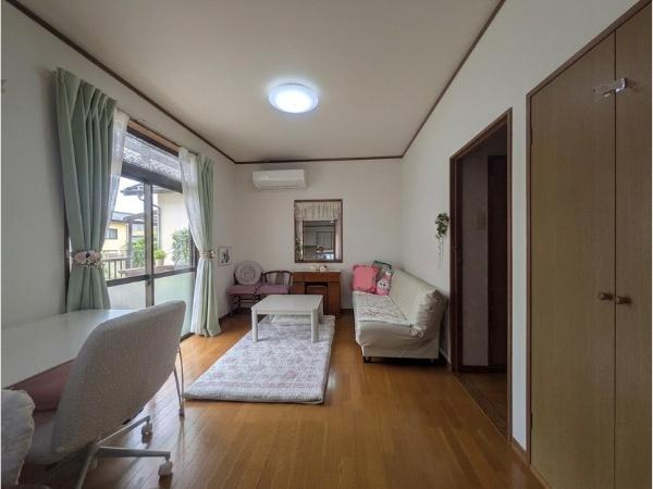 皆春　戸建ての居間・リビング|大きな窓から自然光がたっぷり差し込むリビングです。落ち着いたフローリングが空間を引き締めます。天井照明が明るさをしっかりと確保しています。