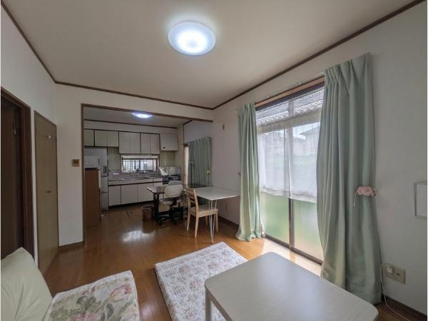 皆春　戸建ての居間・リビング|大きな窓から自然光が入るリビングです。ソファやテーブルなど家具の配置がしやすい空間となっています。隣接したダイニングエリアも見渡せる間取りです。