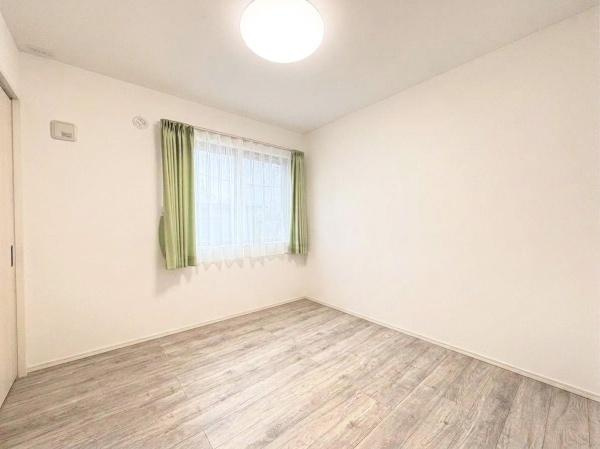 丹生　戸建ての洋室|明るい室内が特徴の洋室です。落ち着いた色合いのフローリングが空間に調和しています。窓から自然光がしっかりと差し込みます。シンプルな内装で使いやすい印象を受けます。
