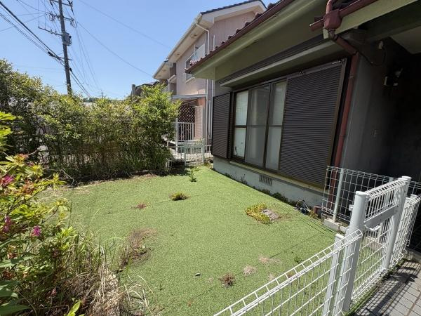 富士見が丘西4丁目中古の庭|陽当たりの良い庭が広がっています。フェンスで囲われておりプライバシーも確保されています。窓からの眺めも楽しめる配置です。手入れがしやすい人工芝が敷かれています。周囲には植栽もあり自然を感じられます。
