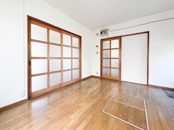 富士見が丘西4丁目中古のキッチン|木目調のフローリングが特徴的なキッチンです。引き戸を開けると洋室に繋がります。